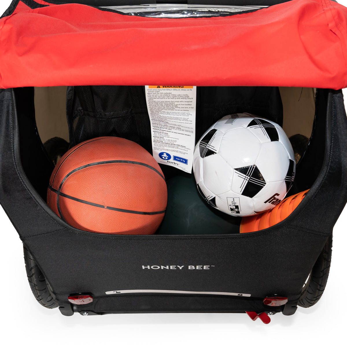 Honey Bee Kid Bike Trailer cargo area filled with sports equipment