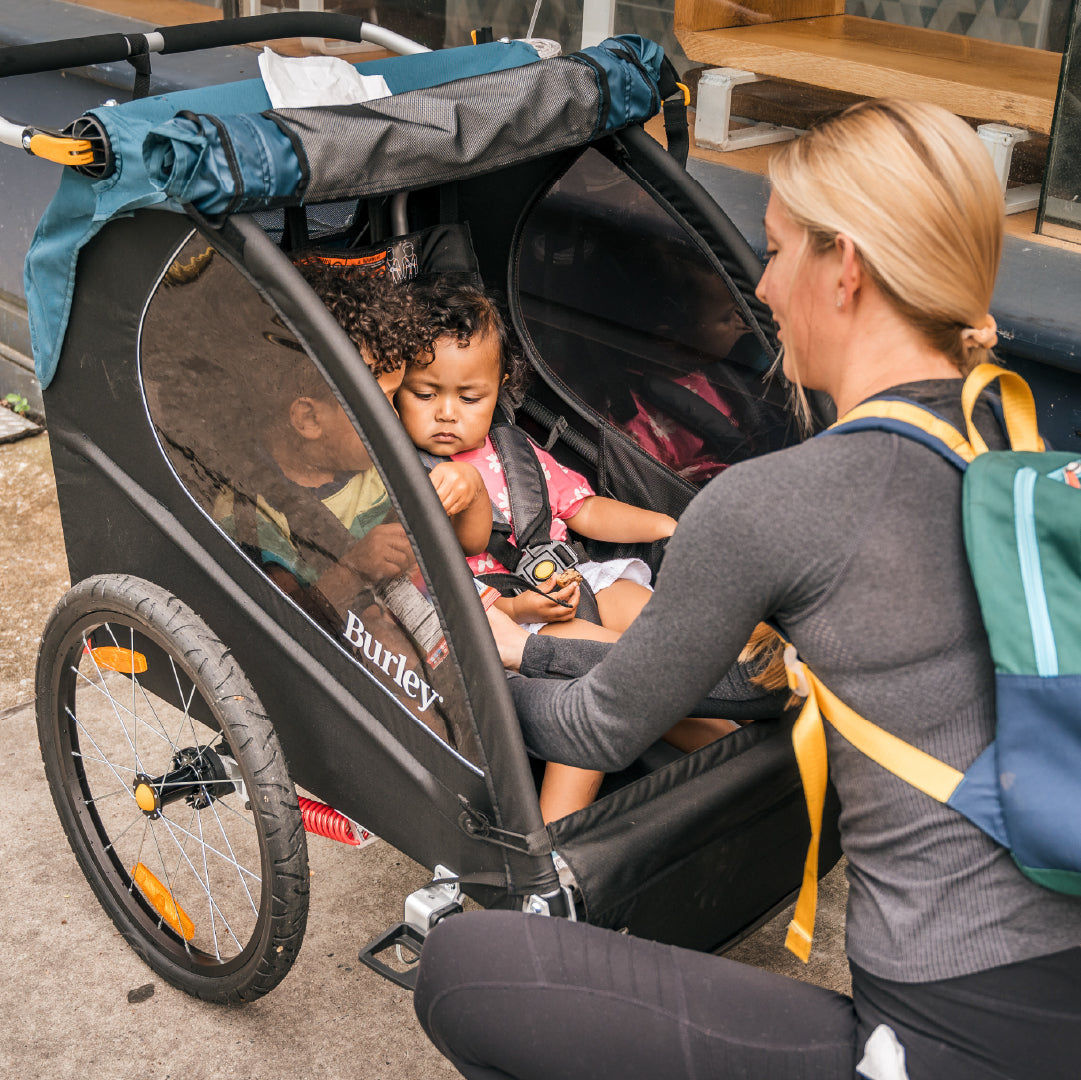 Woman with two children in a Burley Encore X outdoors