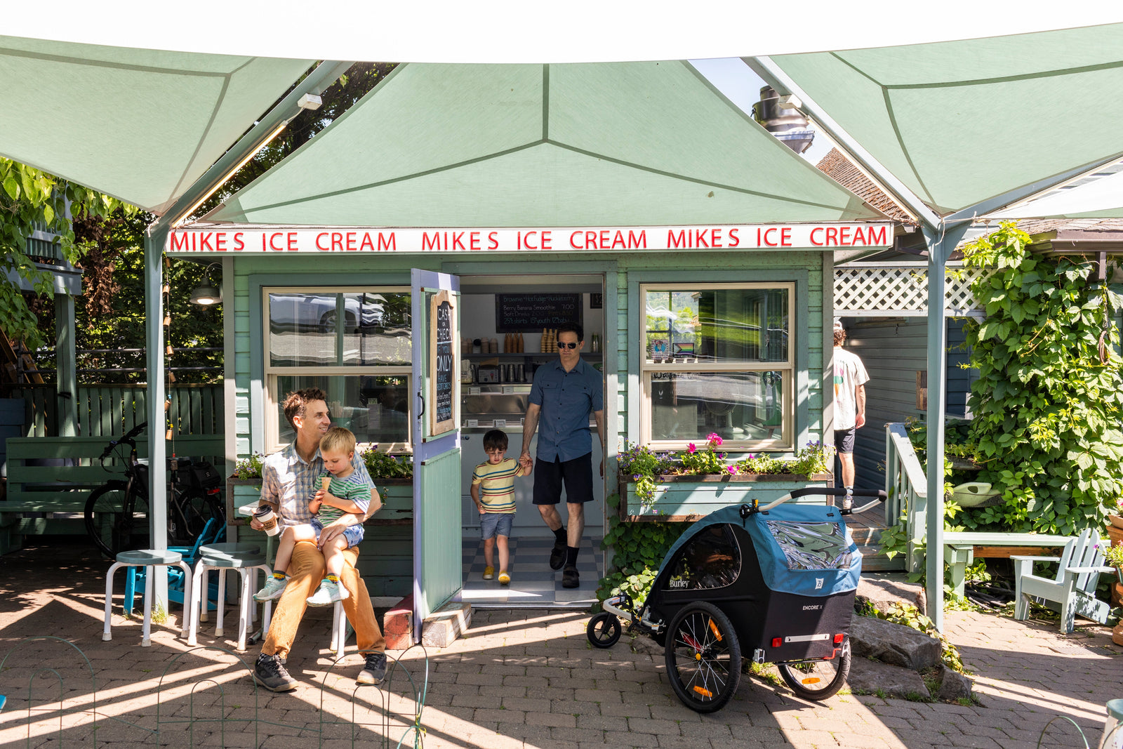 Men in front of ice cream shop with Burley Encore X Trailer