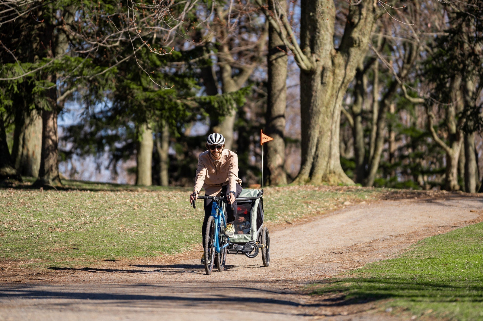 Man towing D'Lite X trailer on bike path