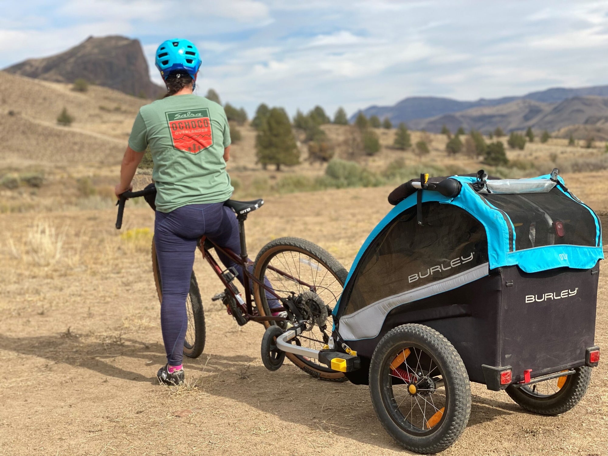 woman with bike and kid bike trailer attached