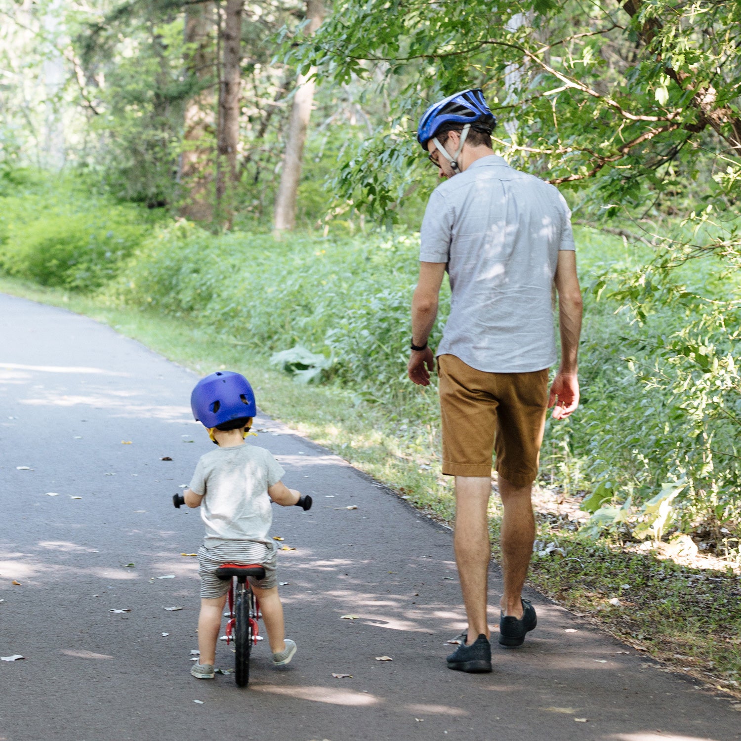 man walking with child biking