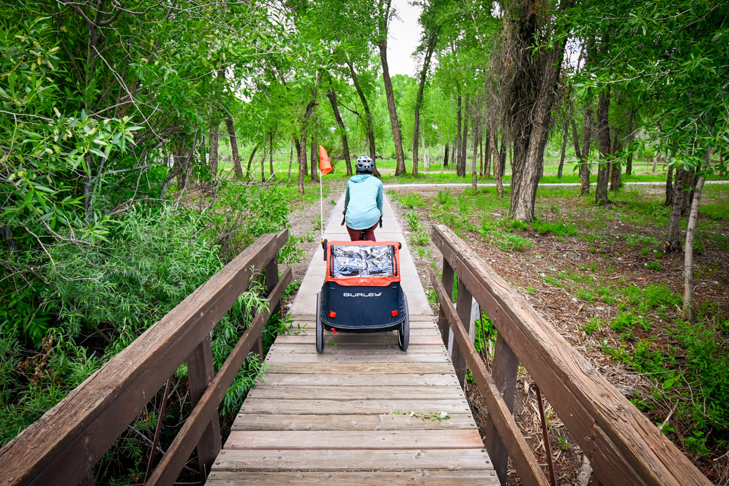 Woman riding with trailer over a bridge