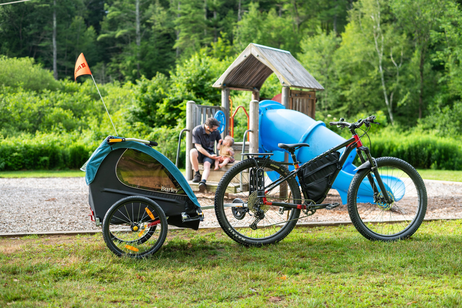 Family at a playground with Burley Encore X Kid Bike Trailer