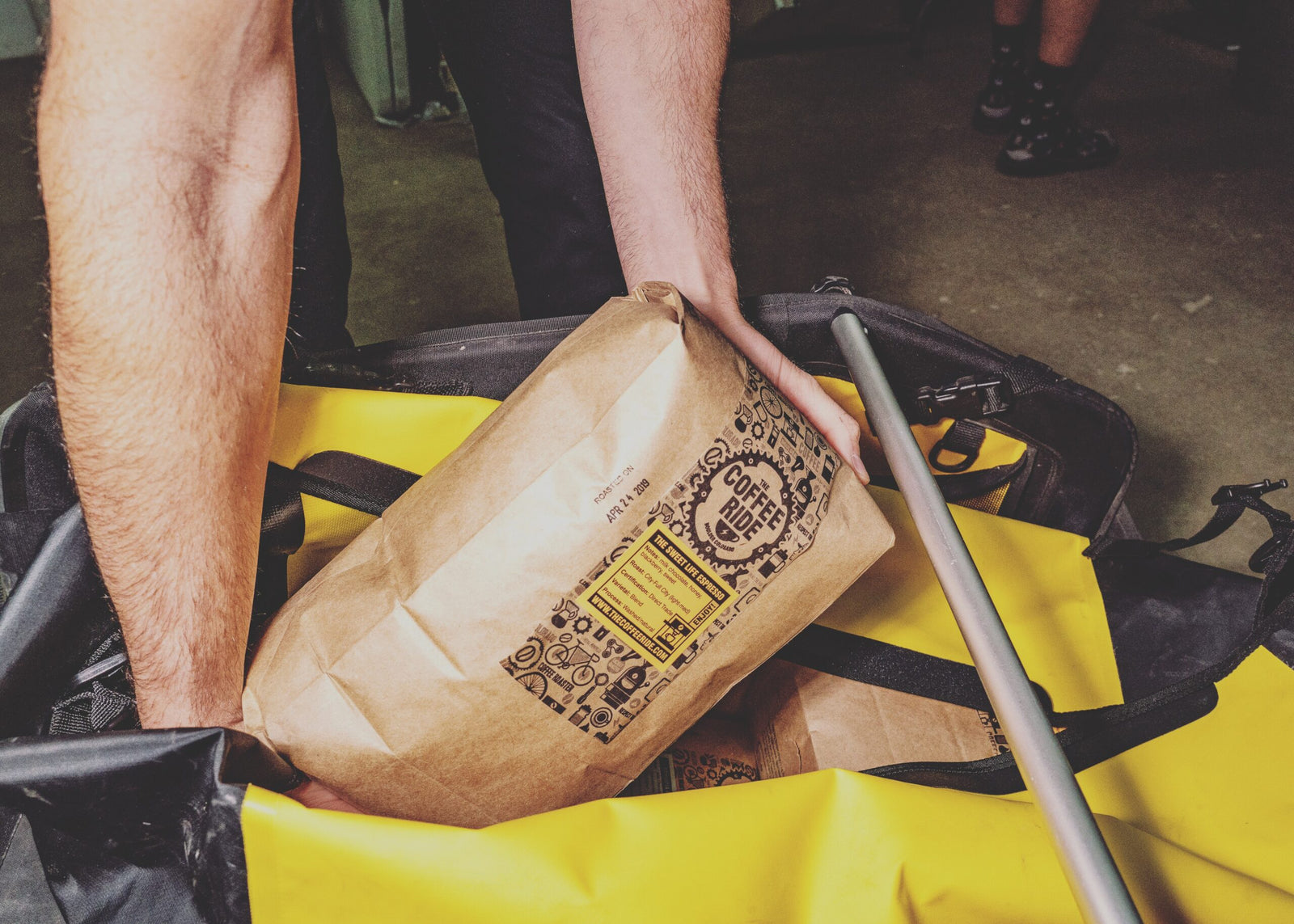 bag of coffee being lifted from a cargo bike trailer