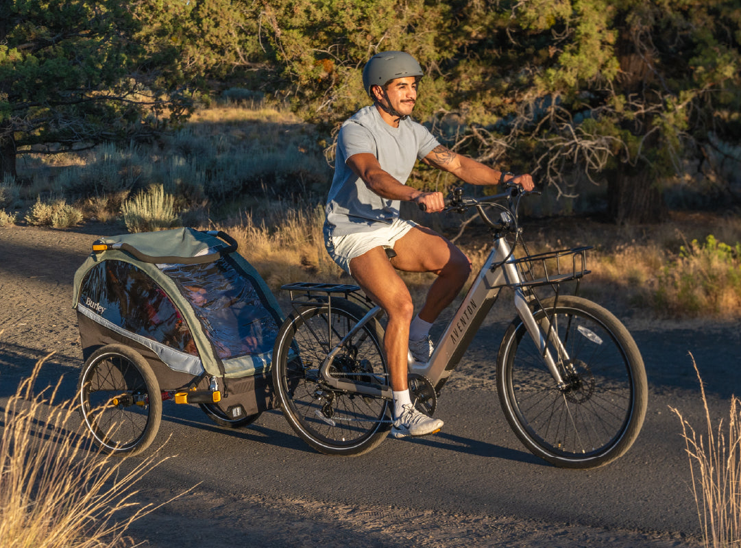 Father biking with children in Burley D'Lite X kid bike trailer